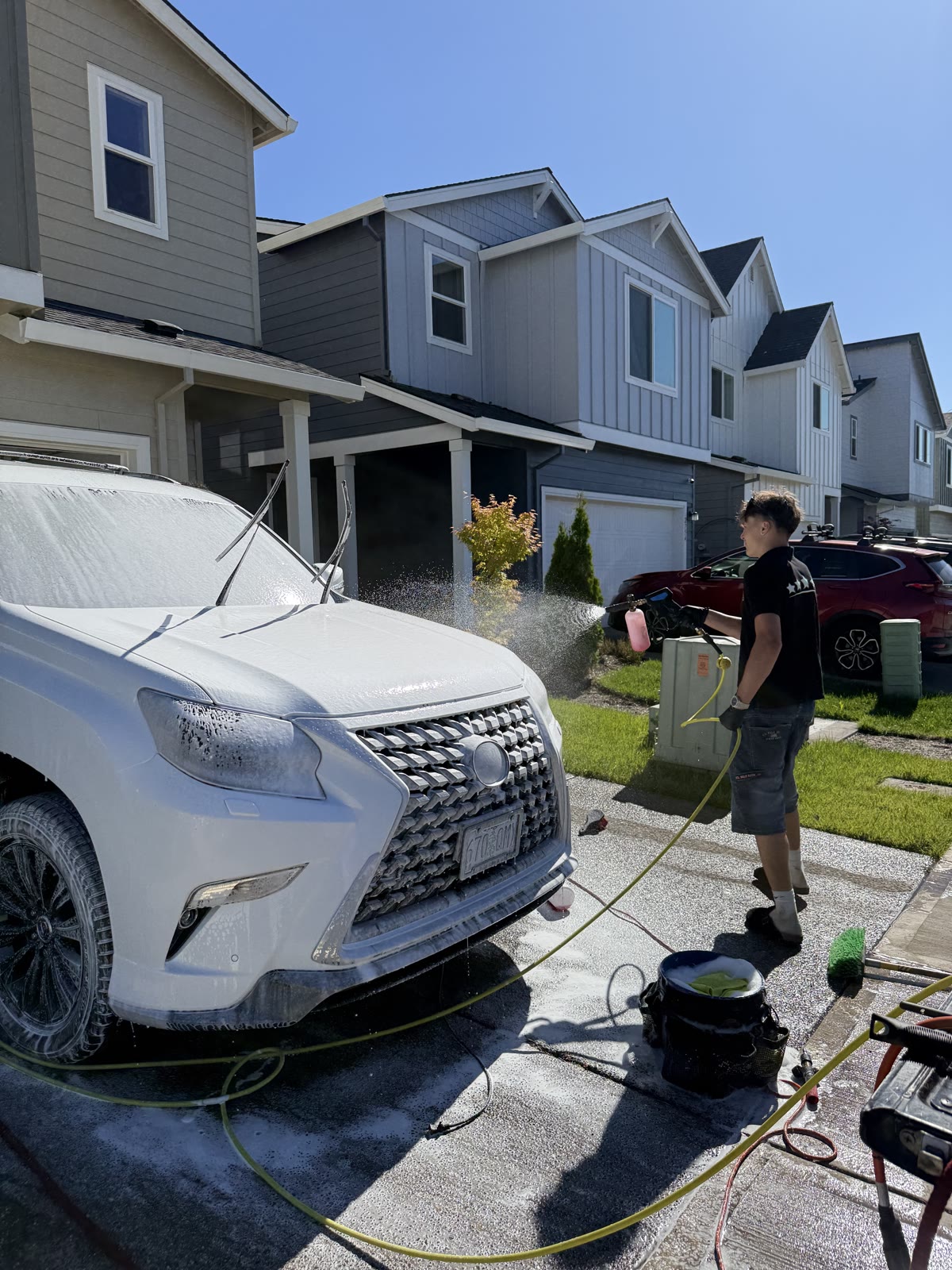 Foaming down a vehicle in the driveway, mid-job